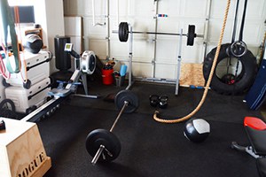 Messy Garage Gym Idea, But Effective Nonetheless. A Rope Hangs Waiting For The Attainment Of Gains.