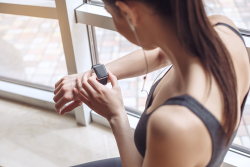 woman working out and looking at her smart watch